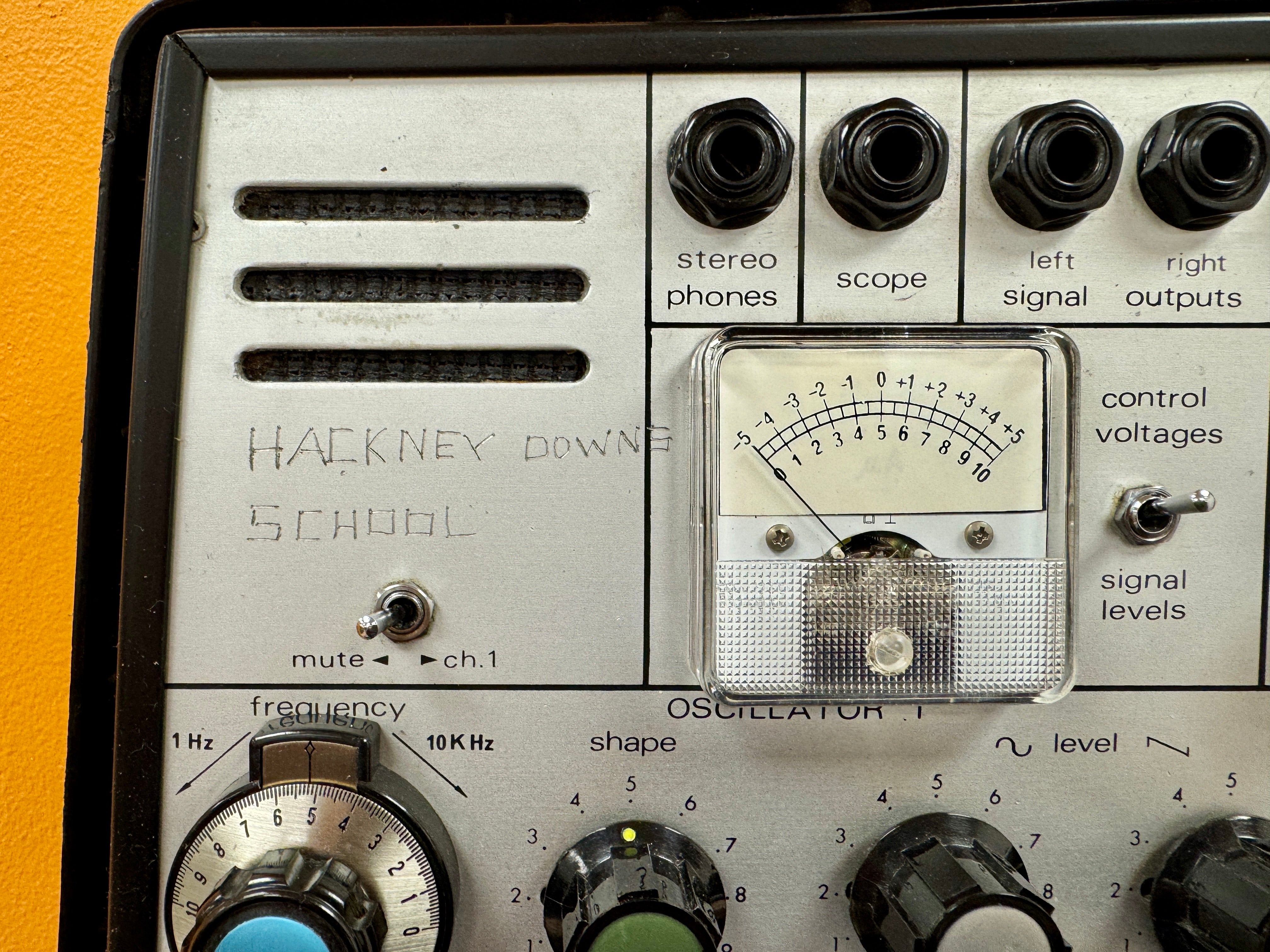 Vintage electronic equipment with control knobs and display on a yellow background