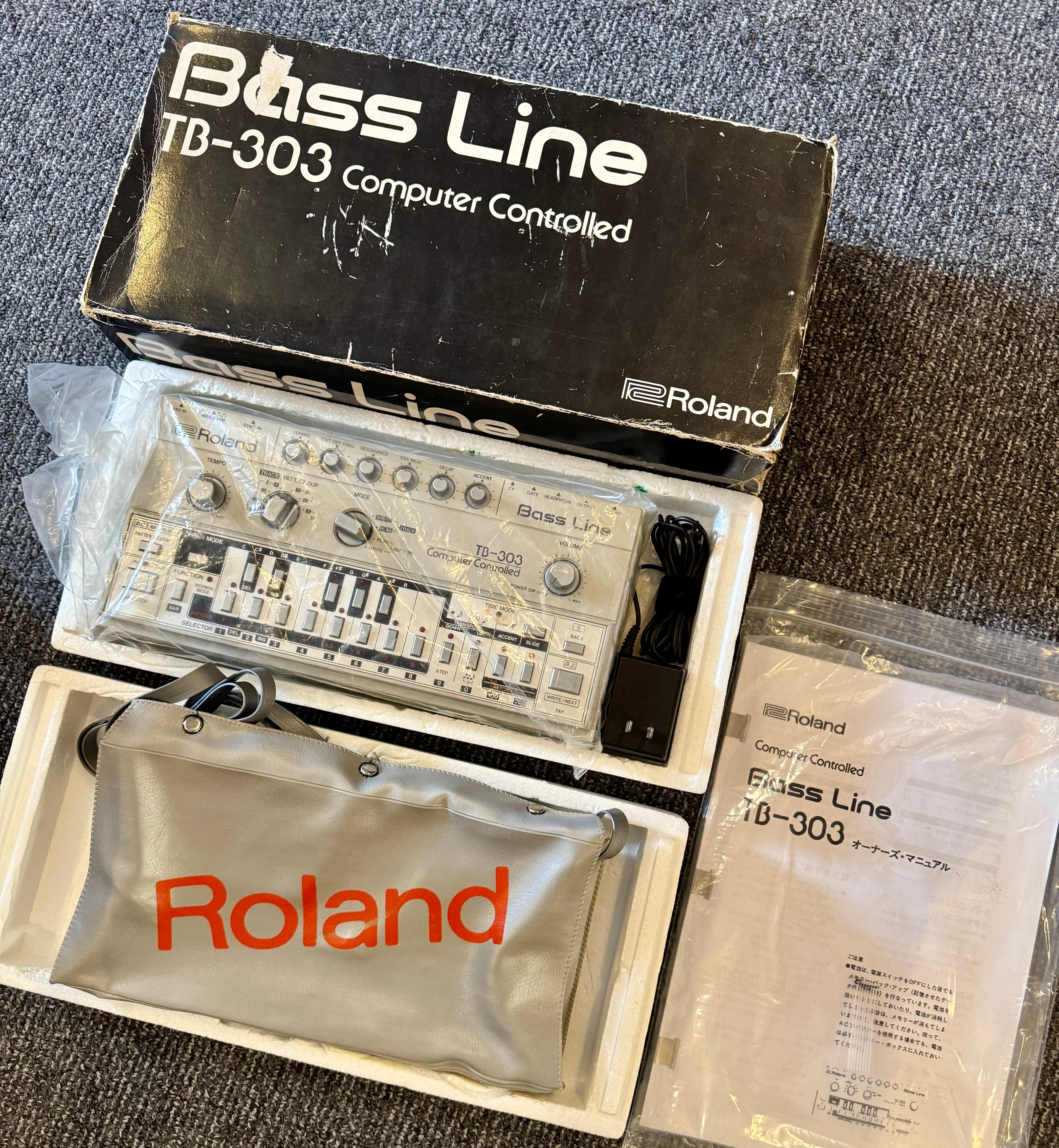 Roland TB-303 Bass Line synthesizer in packaging on a textured surface