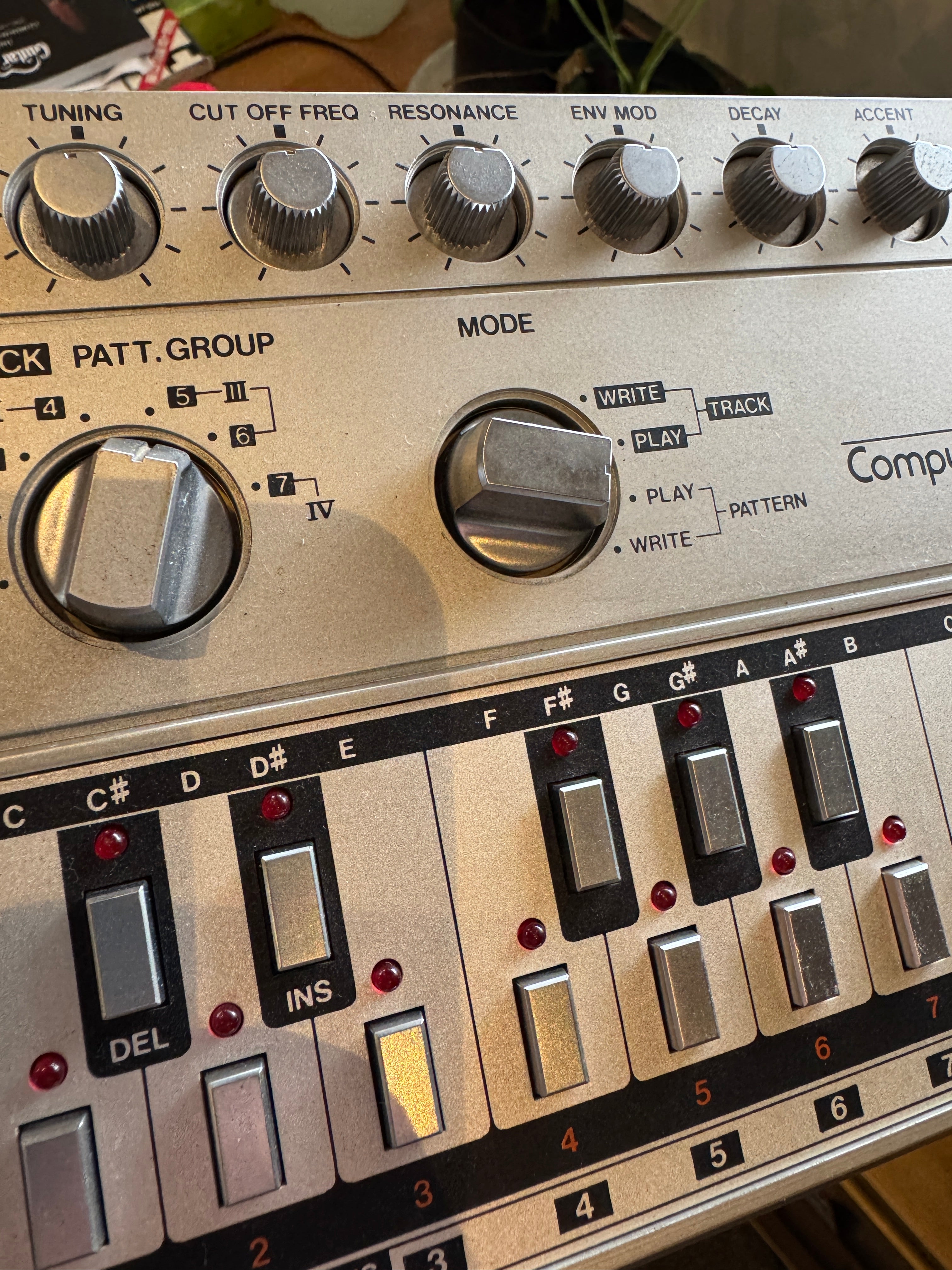 Close-up of a vintage synthesizer with control knobs and buttons.