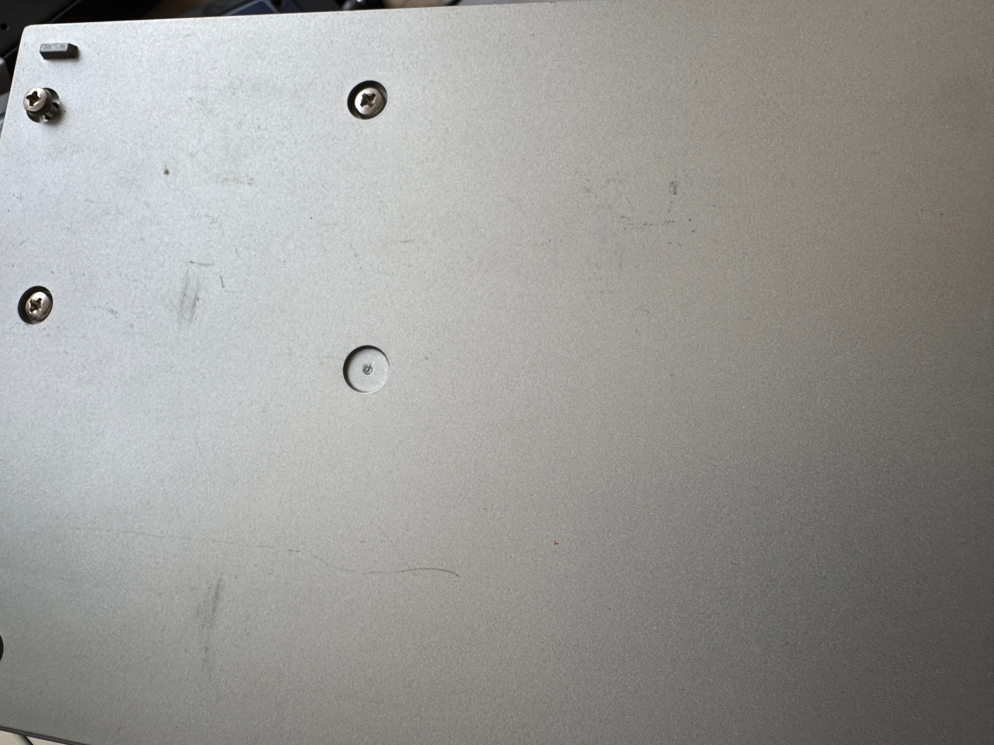 Close-up of a metallic surface with screws and wear