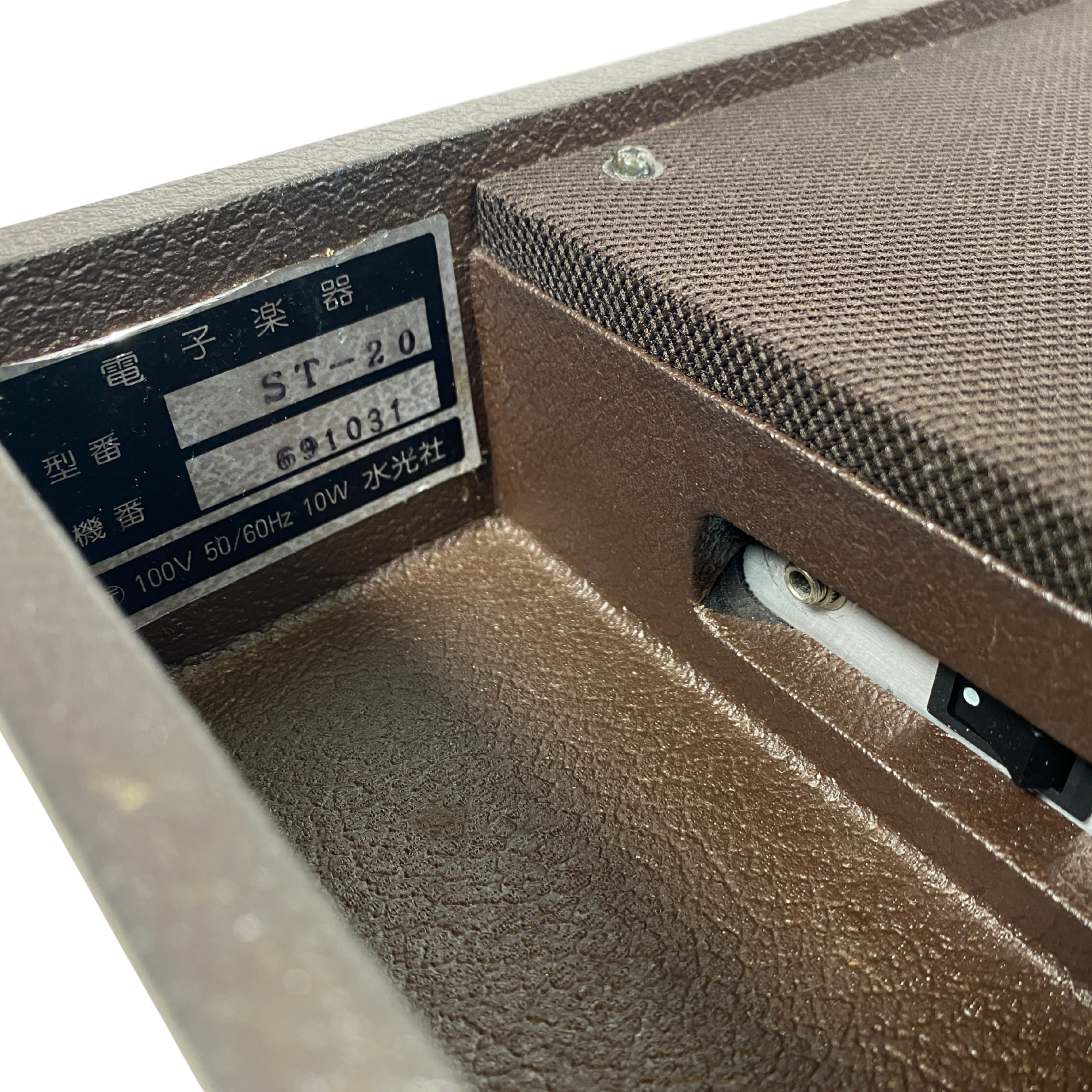 Close-up of a brown electronic device with a label on a white background