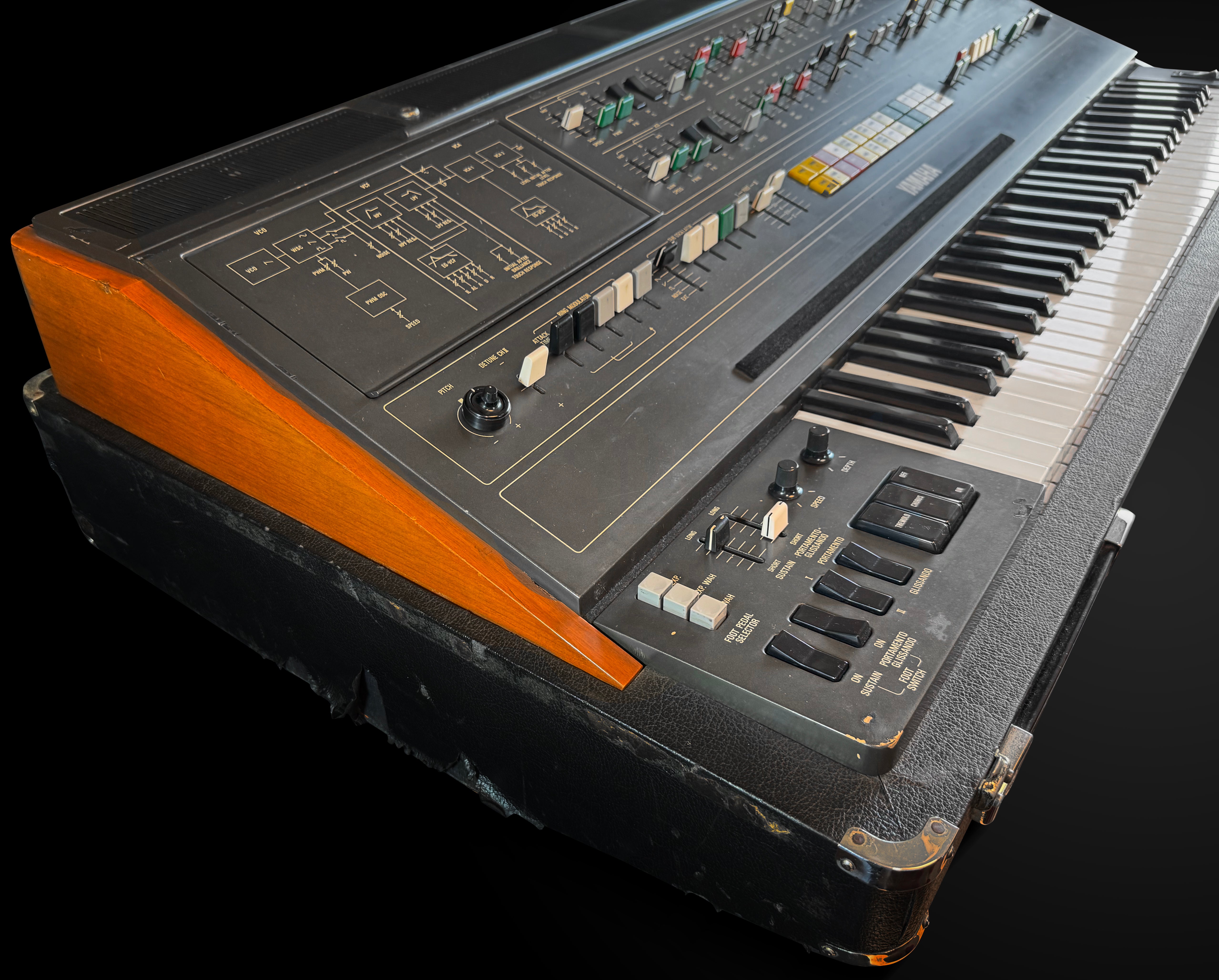 Vintage synthesizer with wooden accents on a black background