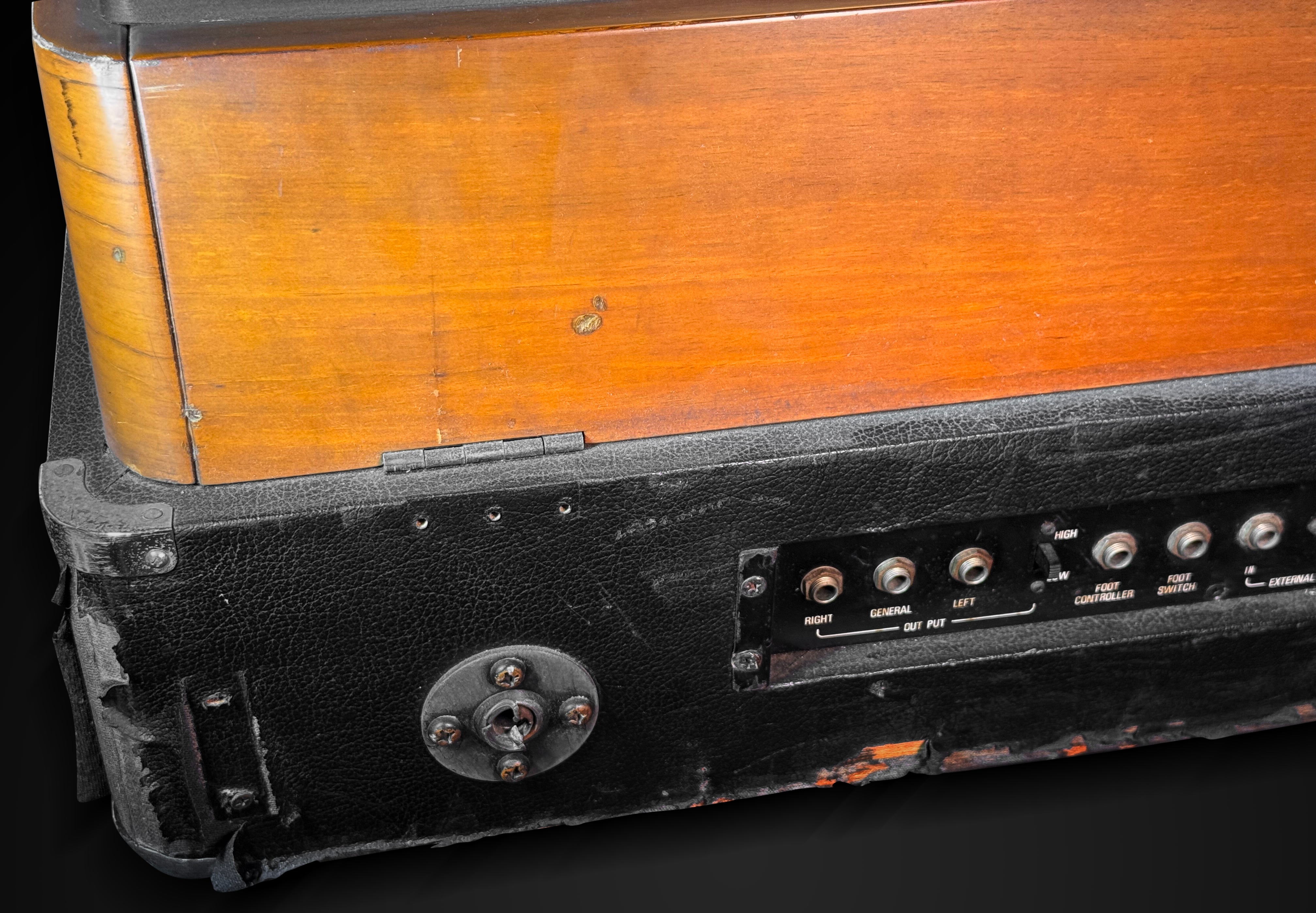 Close-up of an old electronic device with wooden top and black base.